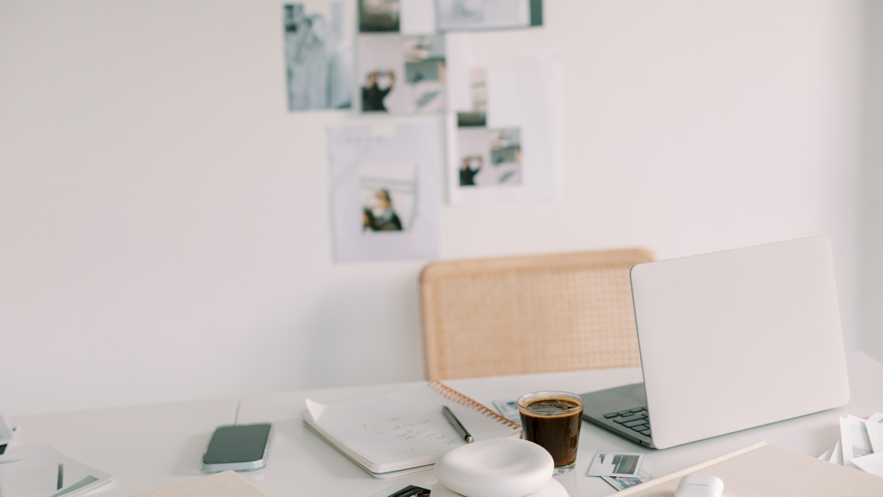 Woman founder's minimalist desk workspace with laptop and coffee — small business growth and expansion planning