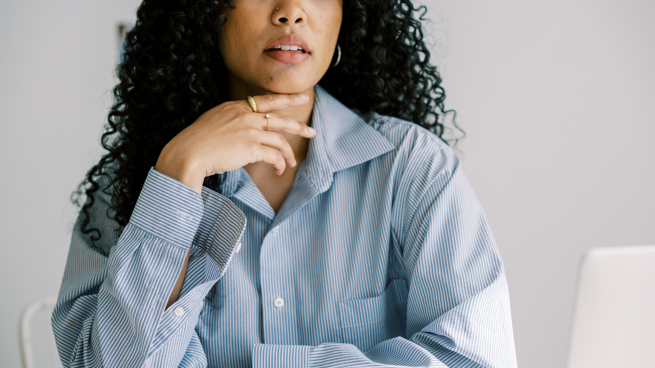 Woman in blue shit sitting at a desk representing a Female CEO