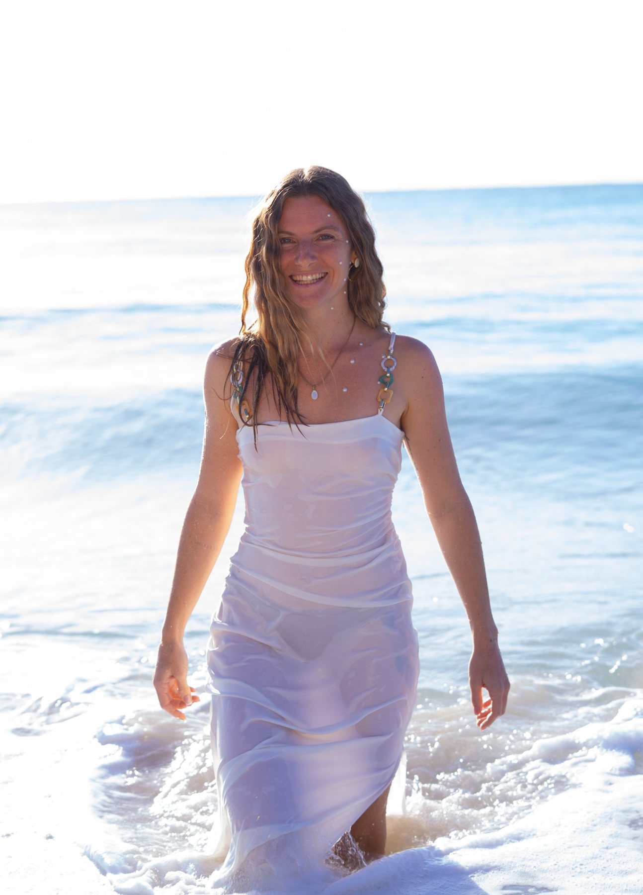 Sina Simon walking out of the sea in a white dress