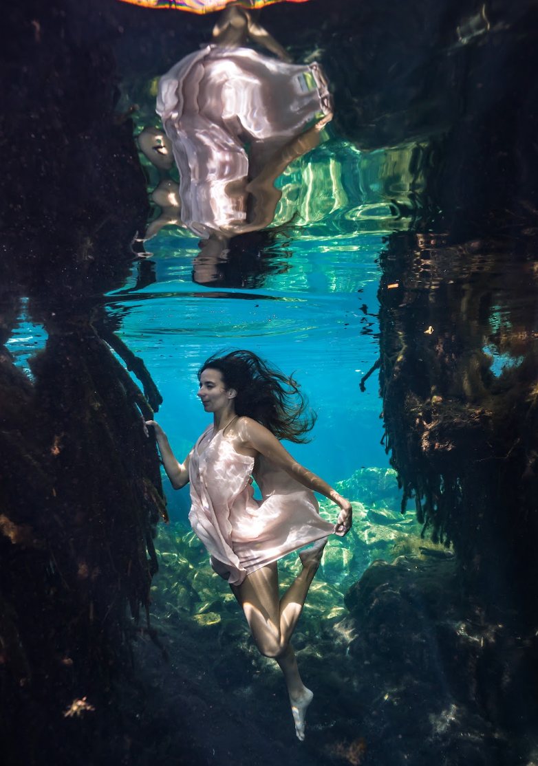Woman in a pink dress reflected on the water surface
