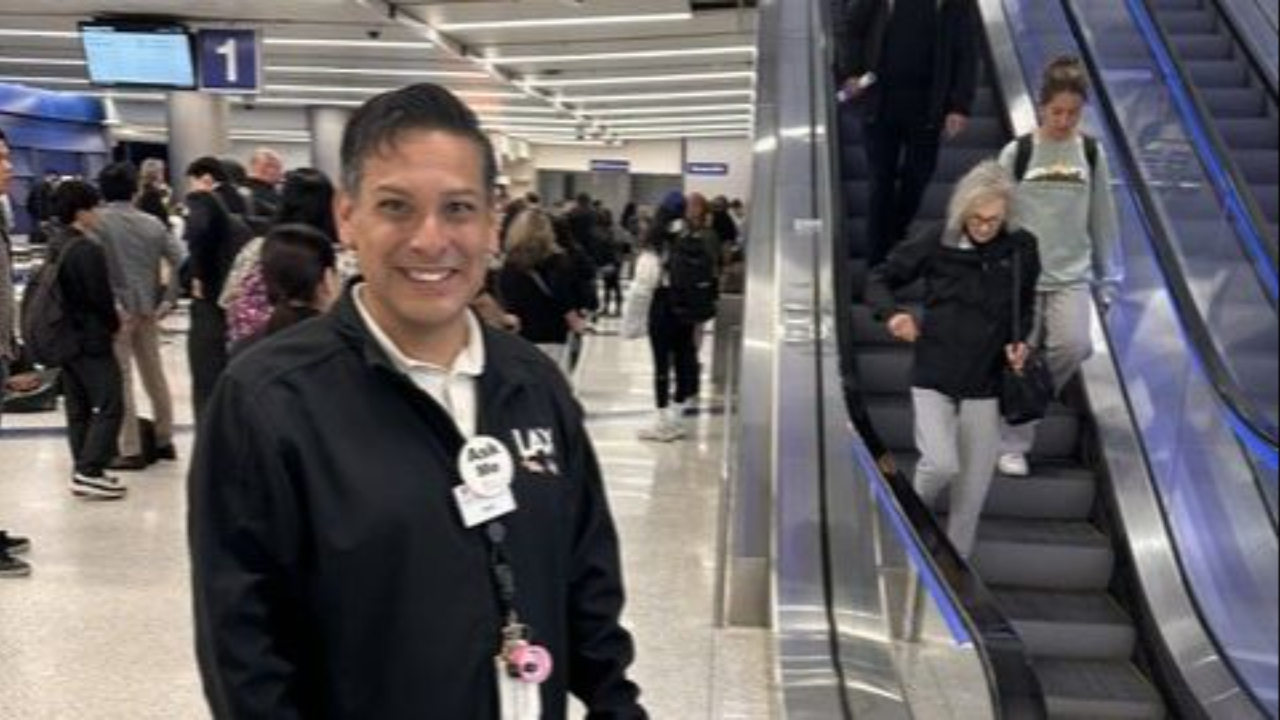 Traveler being warmly welcomed inside a busy airport terminal, illustrating the lost art of the warm welcome in leadership.