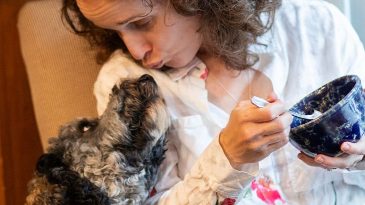 wendy taking a break from eating from a bowl to air-kiss a sweet gray puppy eating disorder prevention relationships with food body family