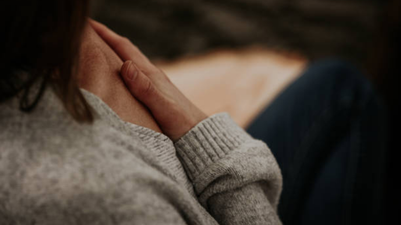 A person holding themselves gently, representing self-compassion, nervous system healing, and creating safety within yourself.