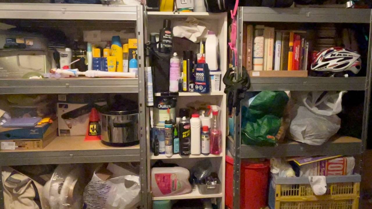 Garage shelving units finally set up and in use, holding cycling gear and household supplies.