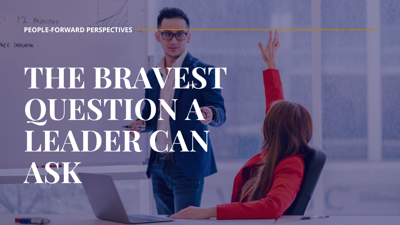 Asian male leader pointing to a female profession how has her hand raised asking a question.