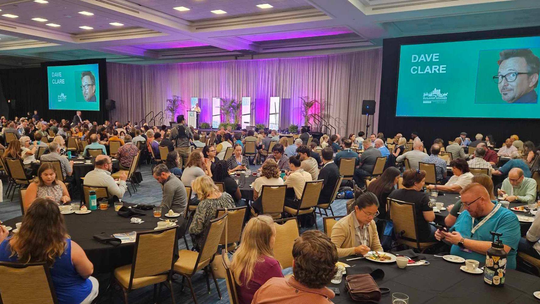 Conference audience and stage at a Dave Clare speaking event