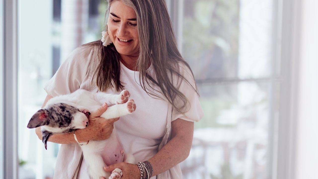 penny holding a new puppy