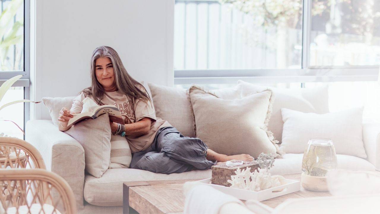 penny sitting on a couch reading a book