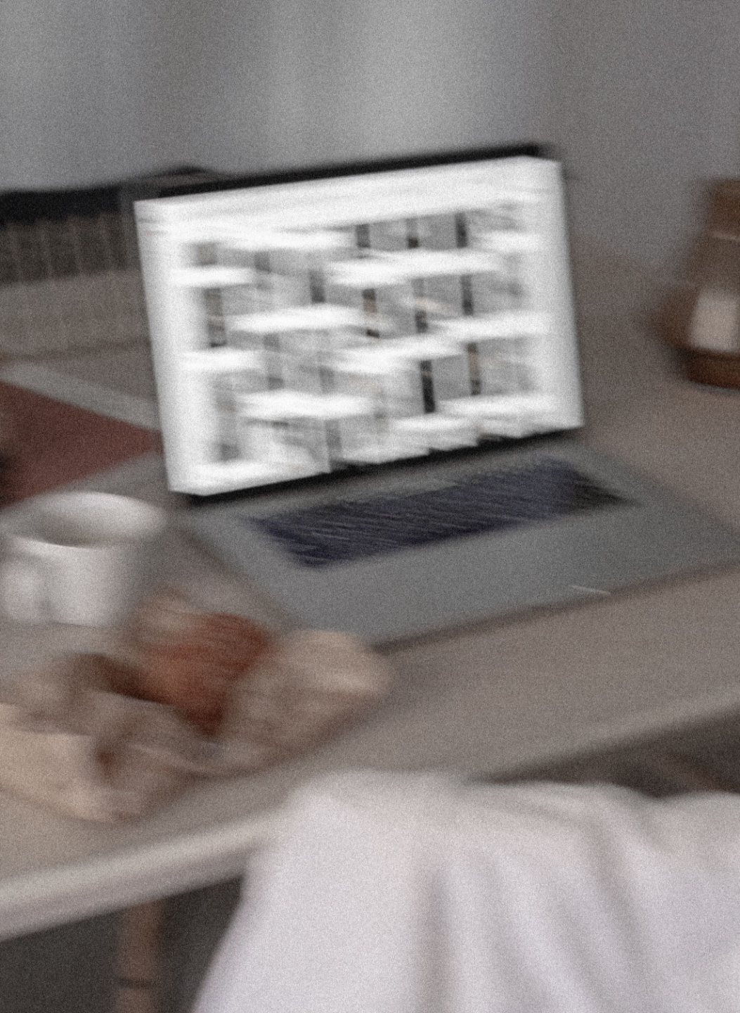 Soft-focus laptop on a desk showing a half-built webpage layout