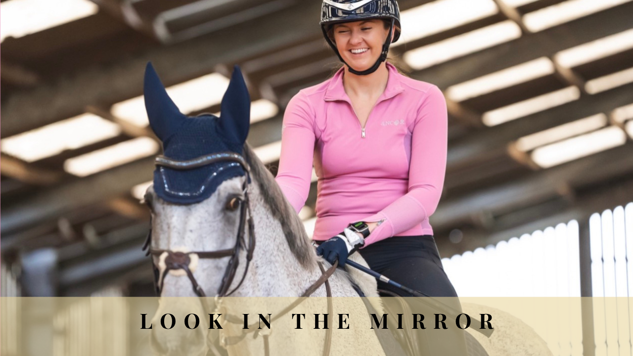 Smiling rider on a grey horse with the words ‘Look in the Mirror’.