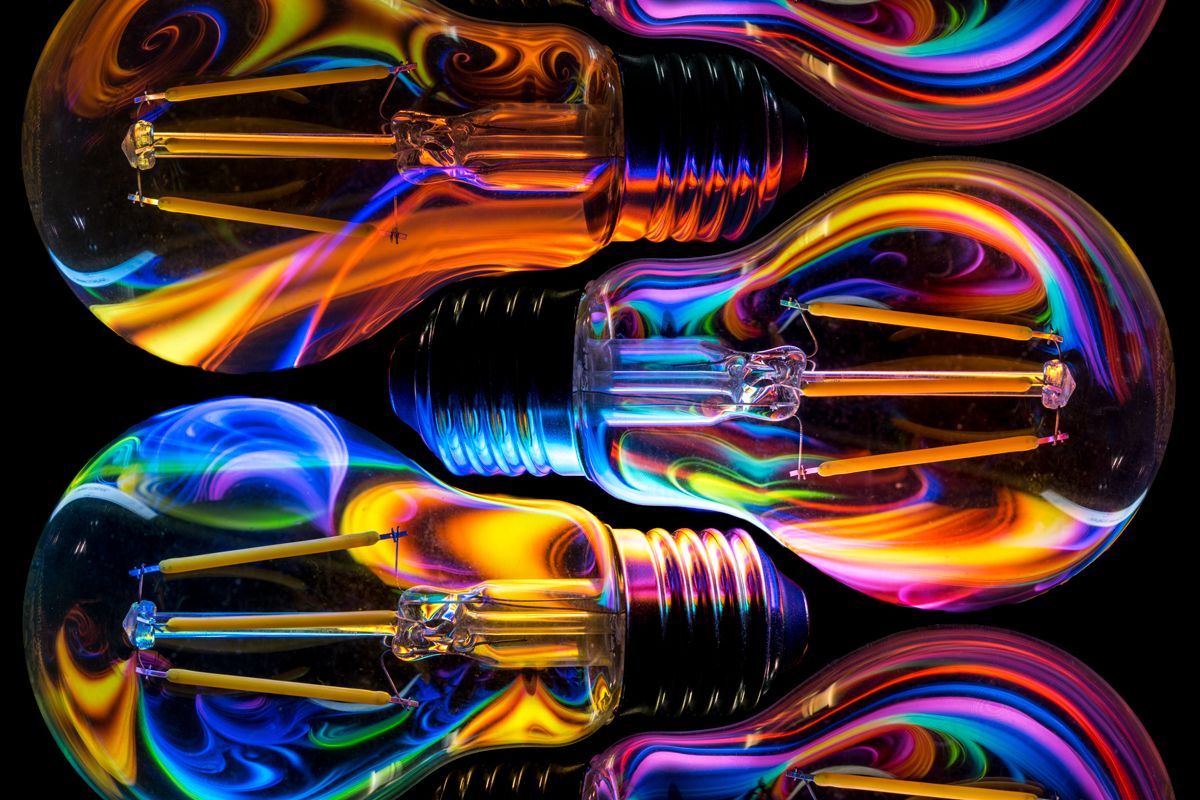 A photograph of a sky full of fireworks exploding over the city of Brisbane, reflected in the river, showing how to take fireworks photography long exposures.