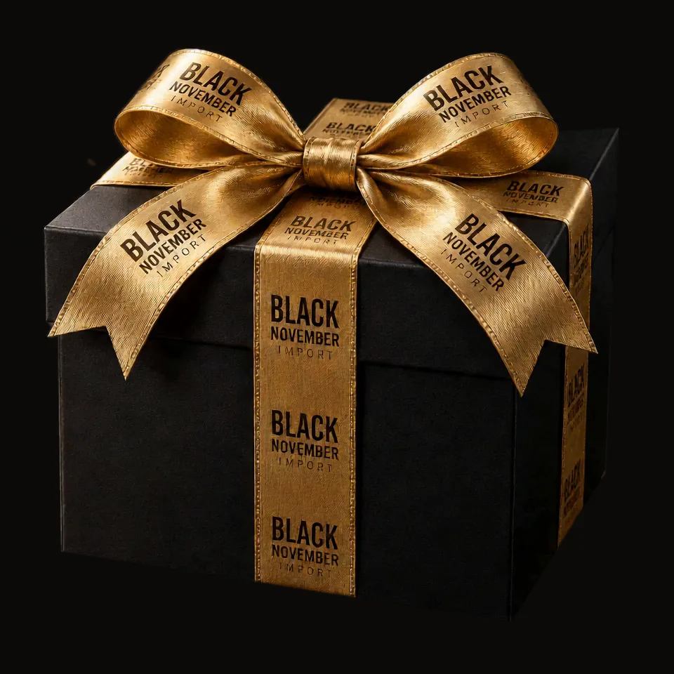 Una caja negra de regalo con la cinta dorada de Black November Import se abre y de ella sale un iPhone 18 Pro Max, que cambia de color con un destello de luz mientras sale de la caja: grafito, plata, azul y burgundy