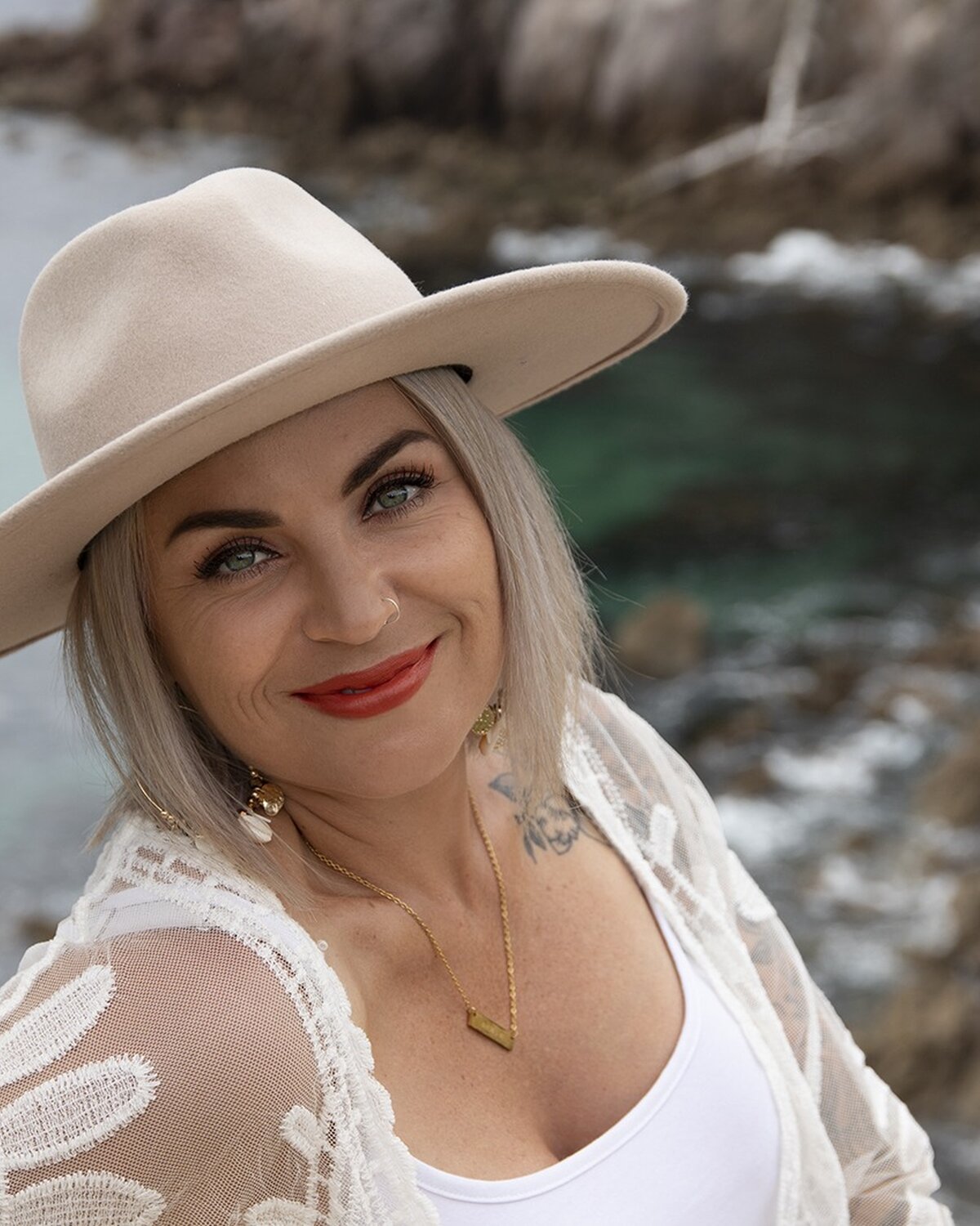 Victoria in a cream hat by the sea.