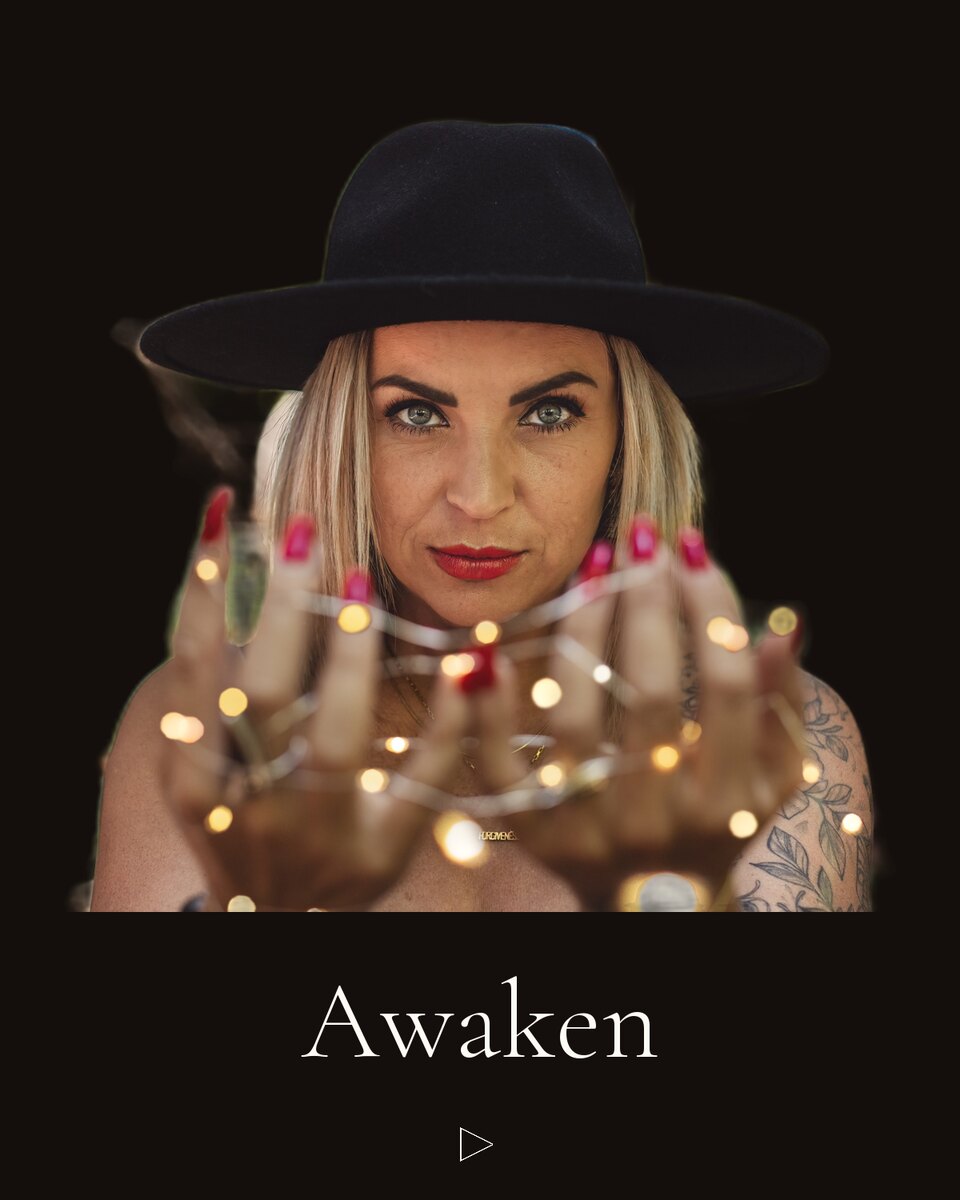 Victoria in a black hat, holding a string of tiny lights.