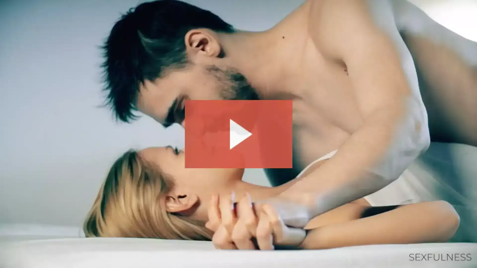 man passionately kissing a woman while lying on top of her