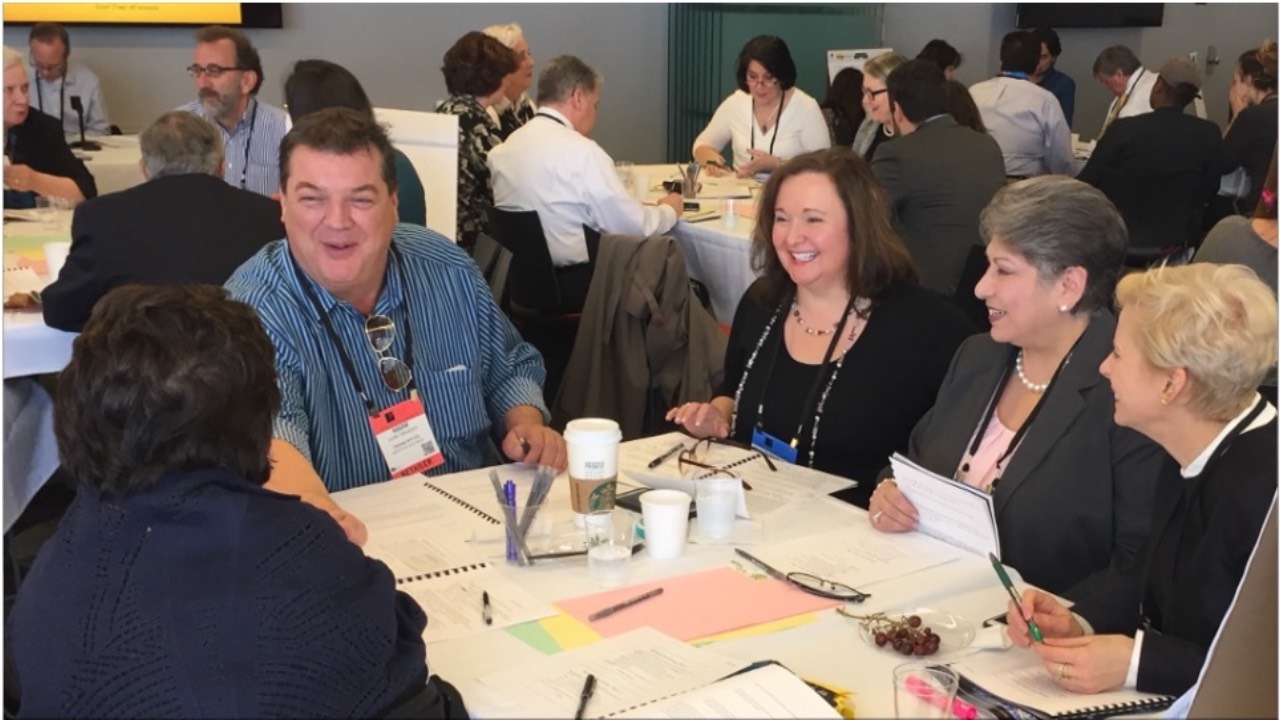 community members engaged in small group conversations