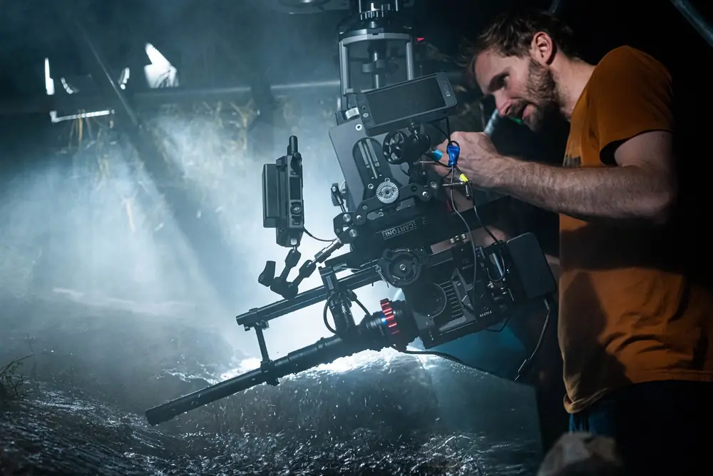 A cinematographer adjusting a camera rig on a night shoot