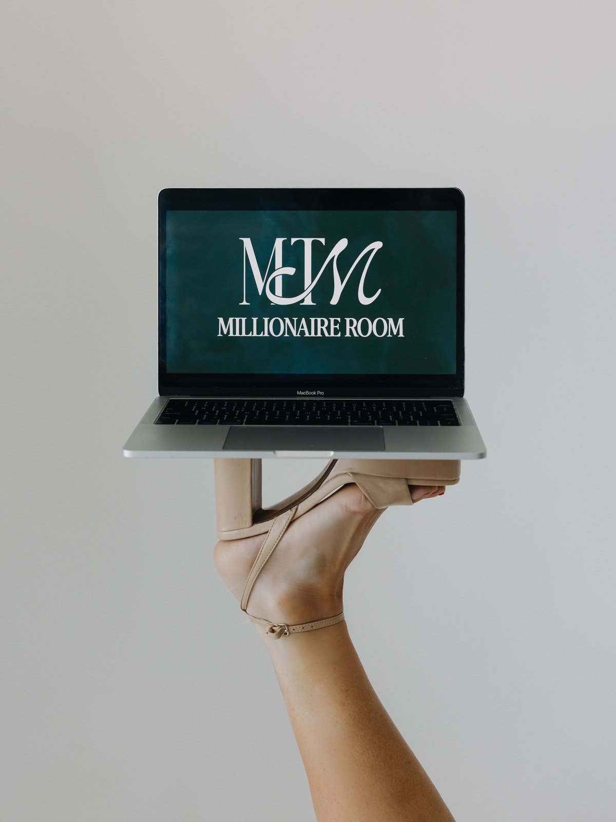 A laptop showing the MTM Millionaire Room, balanced on Mal's heel