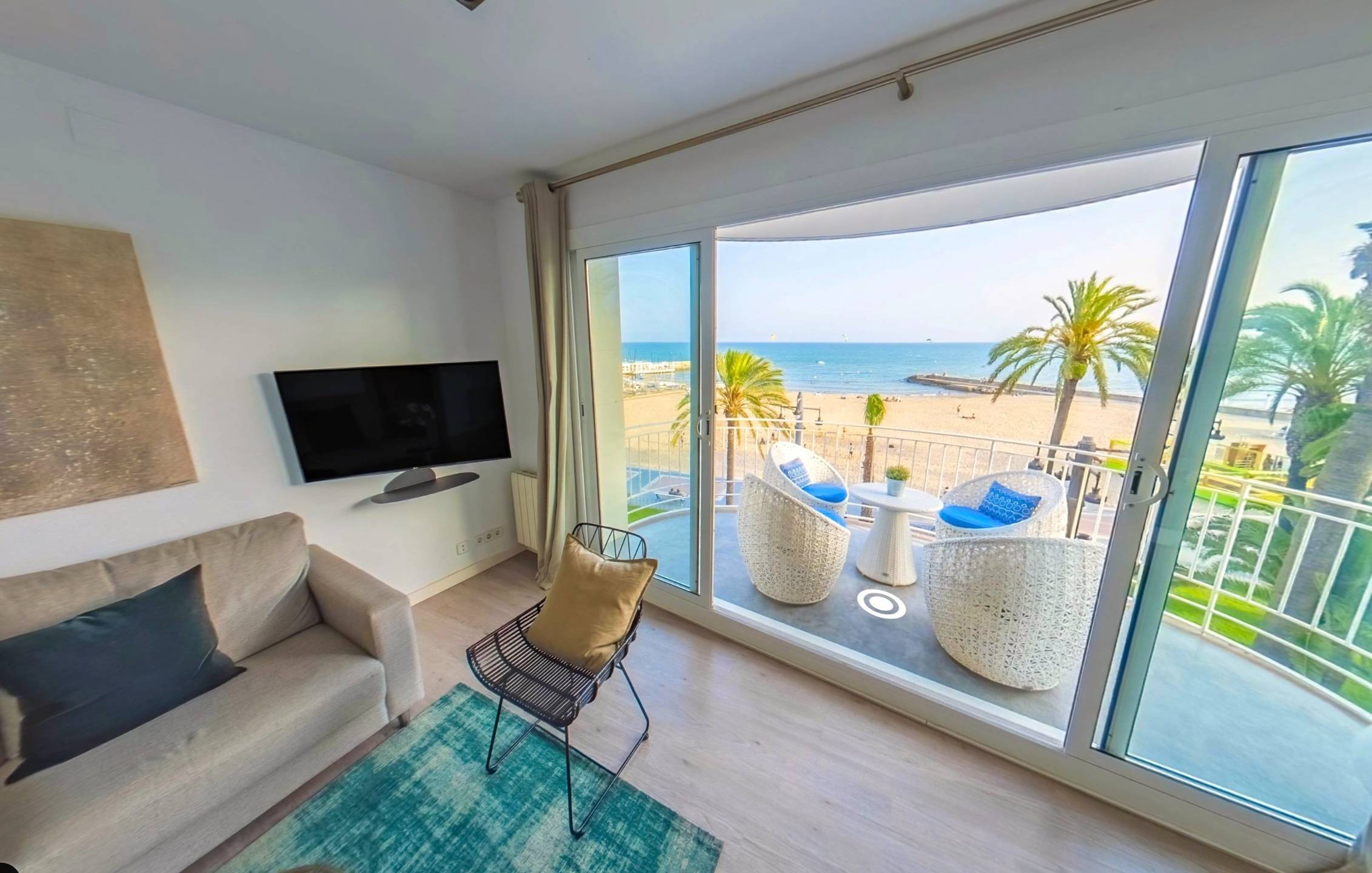 A virtual tour of a bright seaside apartment, with a navigation hotspot leading onto the balcony.