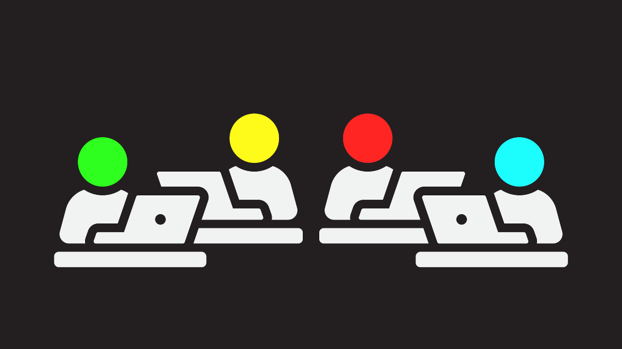 Four people sat at desks with open laptops working, all have different colour heads in green, yello, red and blue