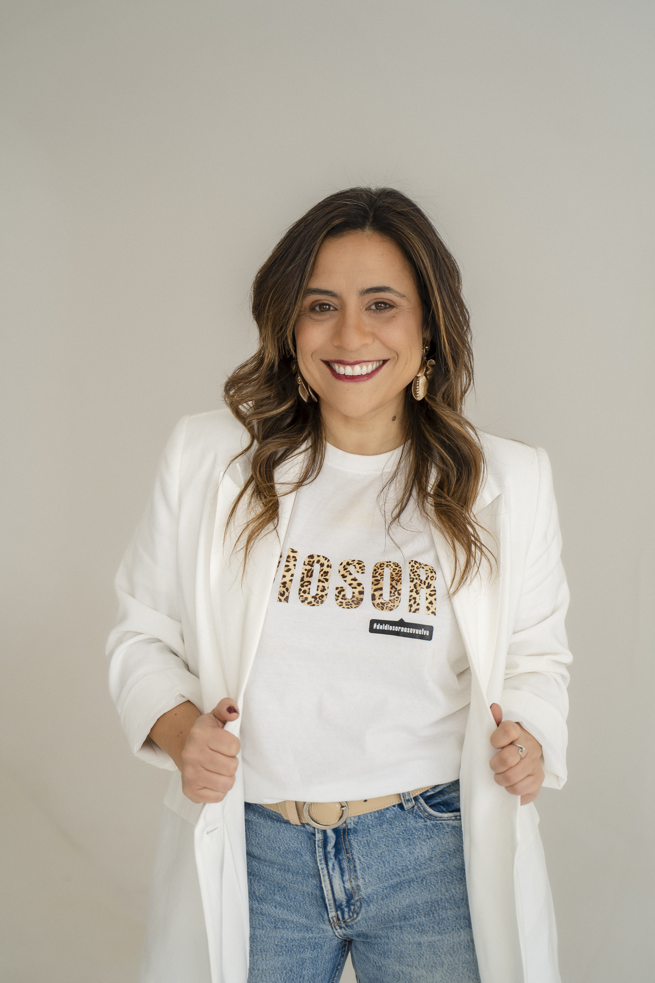 Vicky Zorrilla sonriendo con remera DIOSOR y blazer blanco
