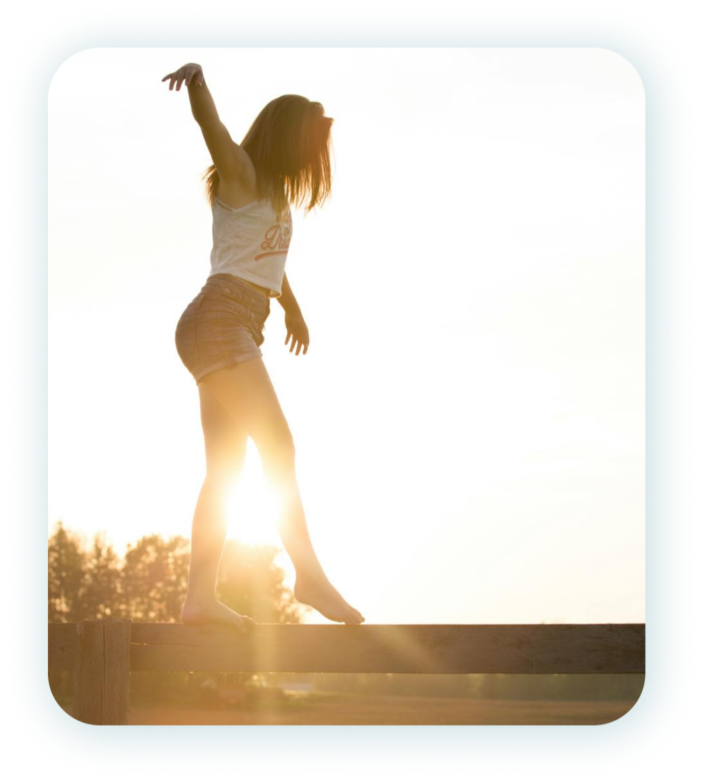A woman arms open in the sunlight