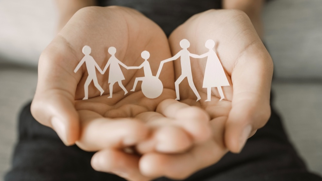 Hands with paper cutouts of people