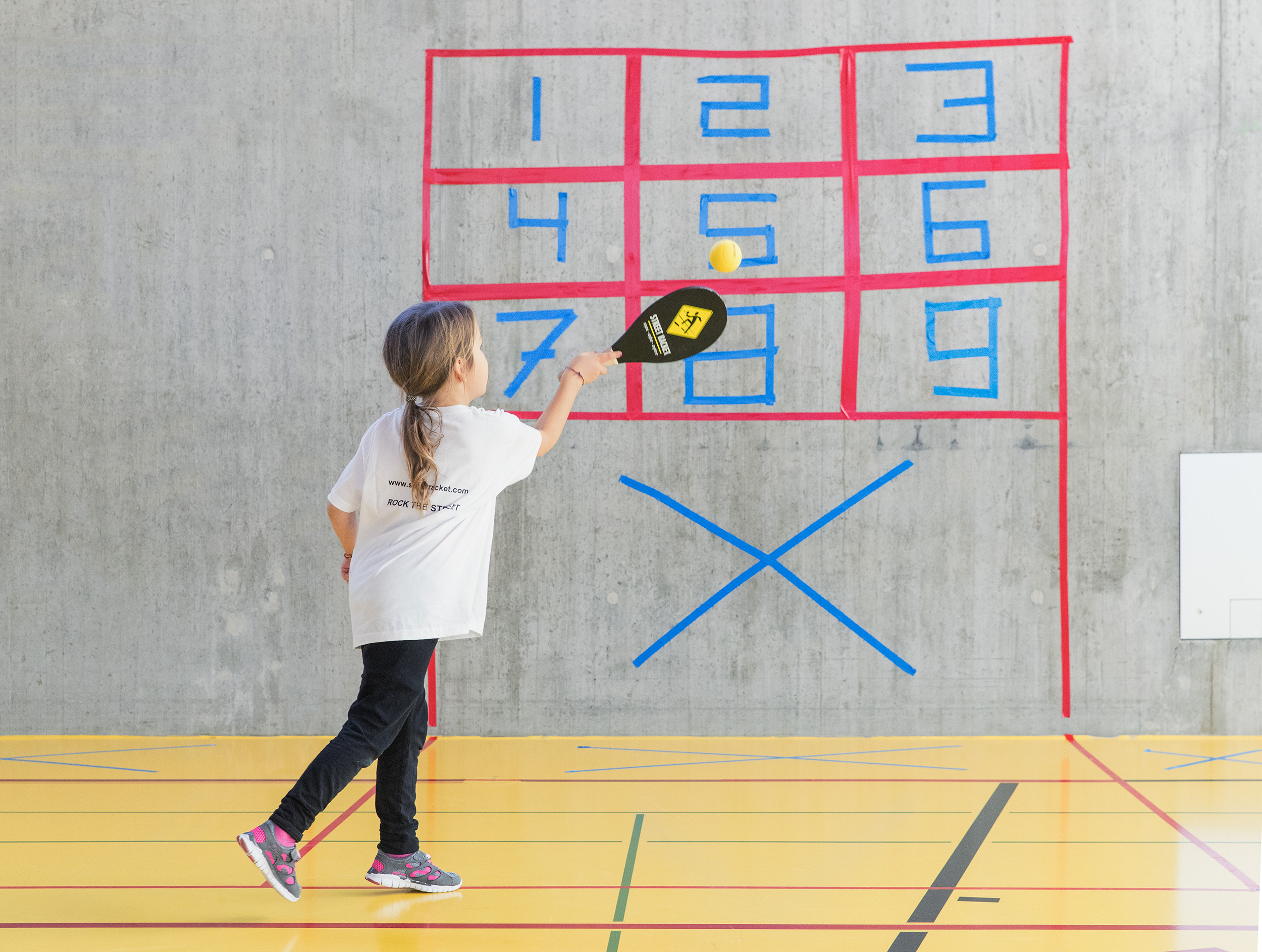 Children playing Street Racket on a court with numbers