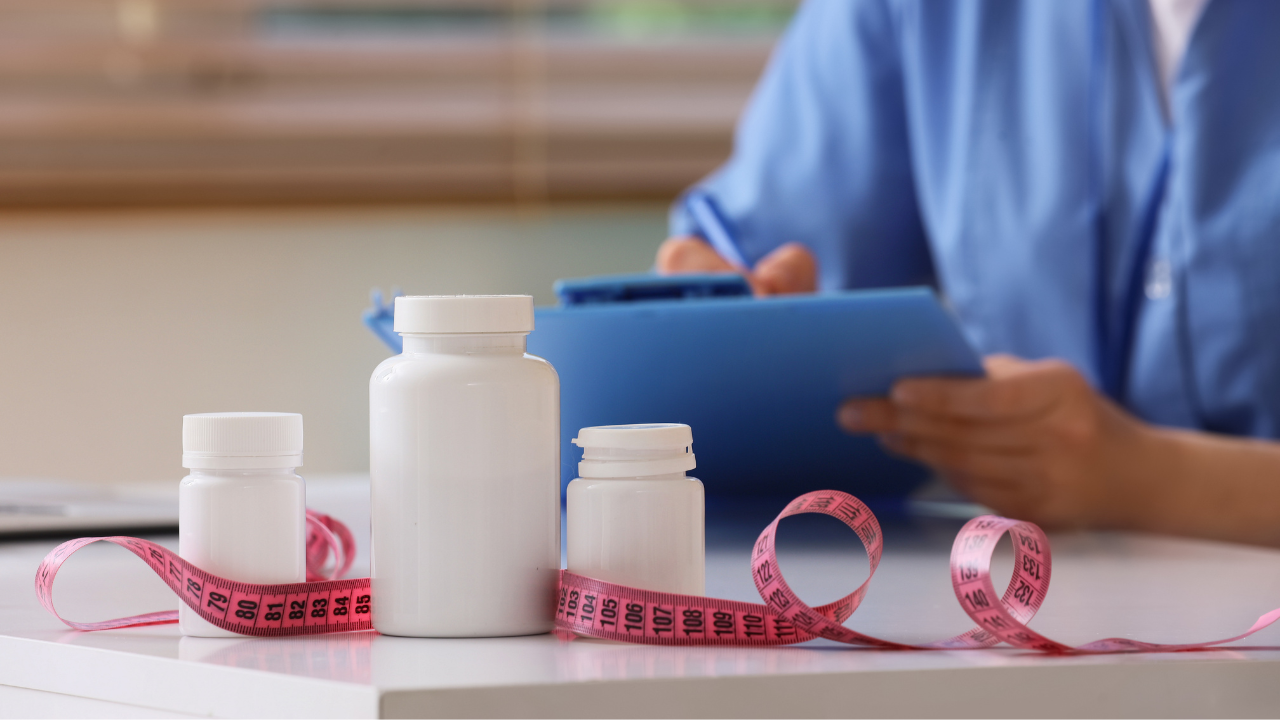 Medication bottles on table with doctor in background