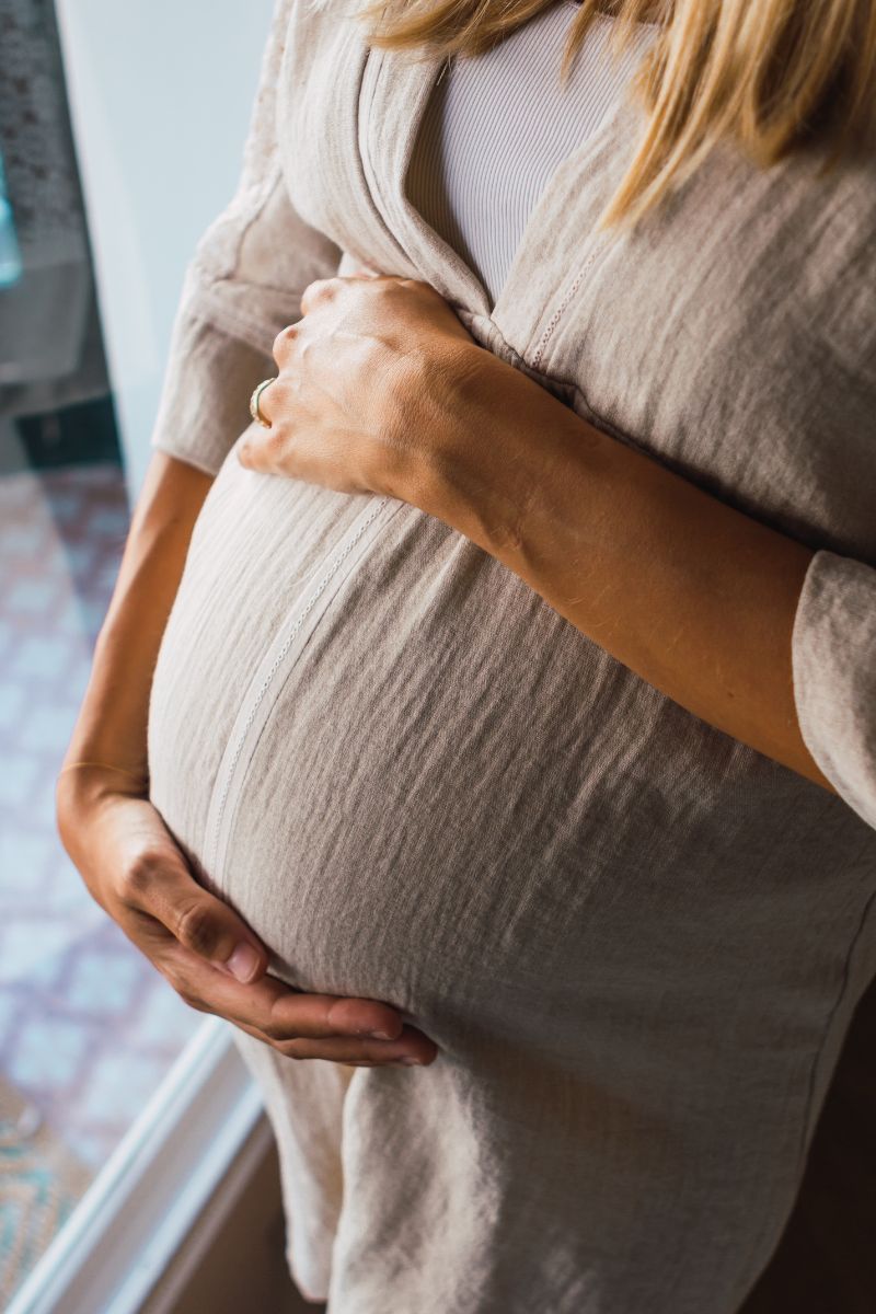 Pregnant woman with arms on her stomach