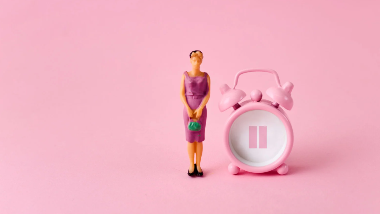 woman figuring standing against a pink background