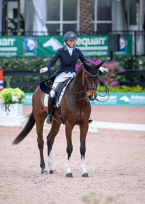 A smiling rider embracing her horse with the reins loose after a rewarding ride