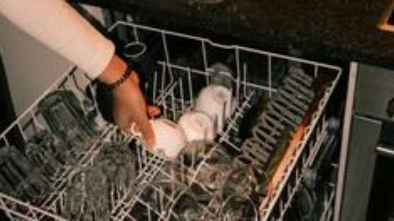 Half-loaded dishwasher with forks facing up, illustrating why working moms and managers can't delegate