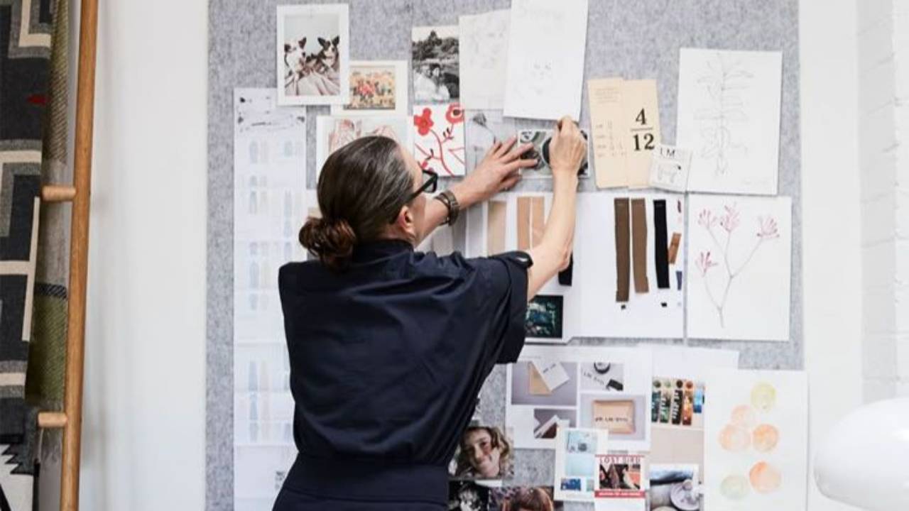 Professional woman arranging a cork board of ideas and design. Photo credit - Alisha Gore