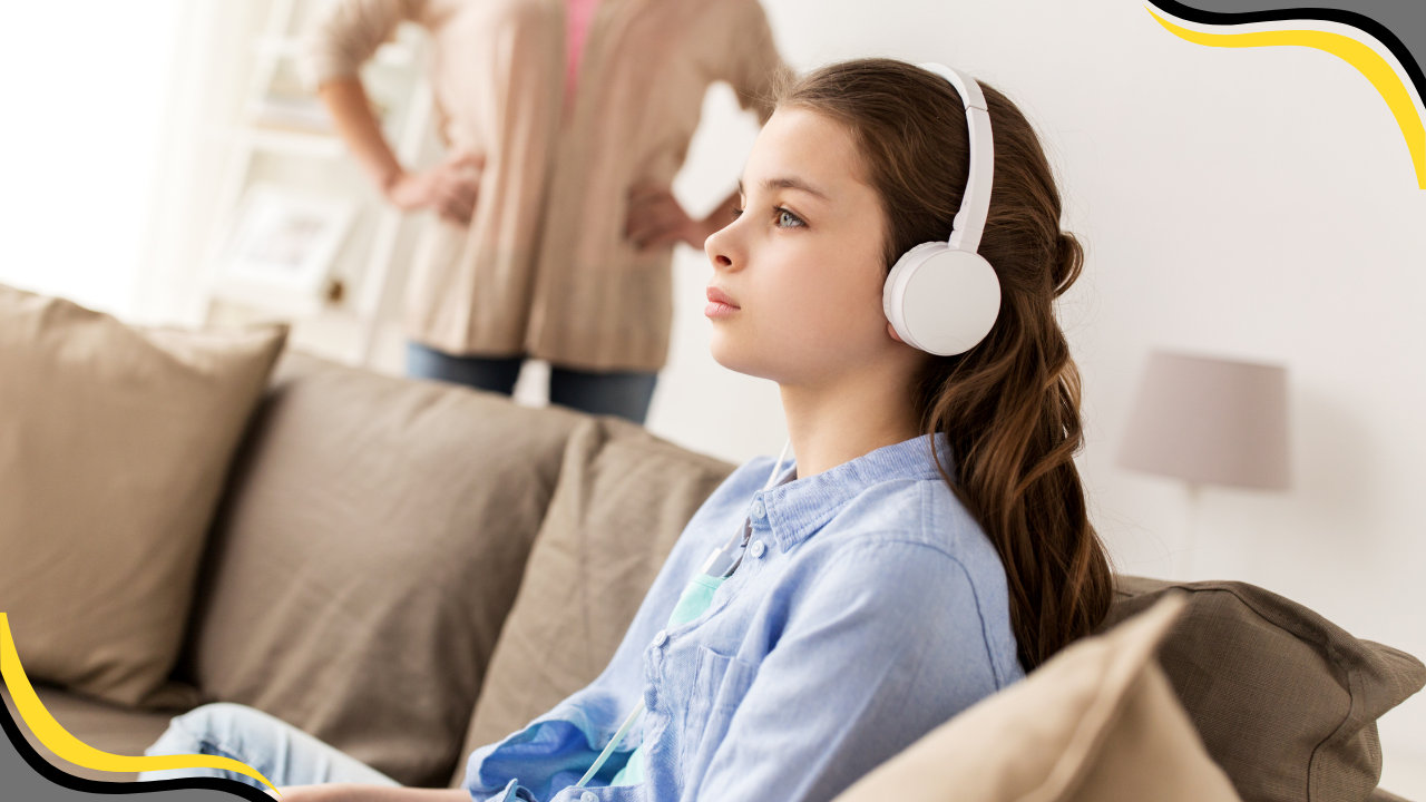 teen girl with headphones playing a game and ignoring her mom