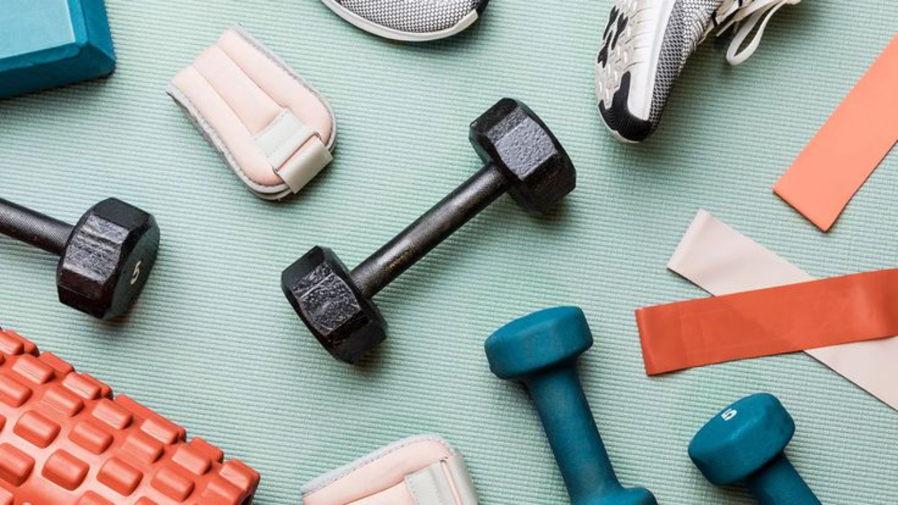 Flat lay of dumbbells, resistance bands, and workout gear for strength training and midlife fitness for women over 40.