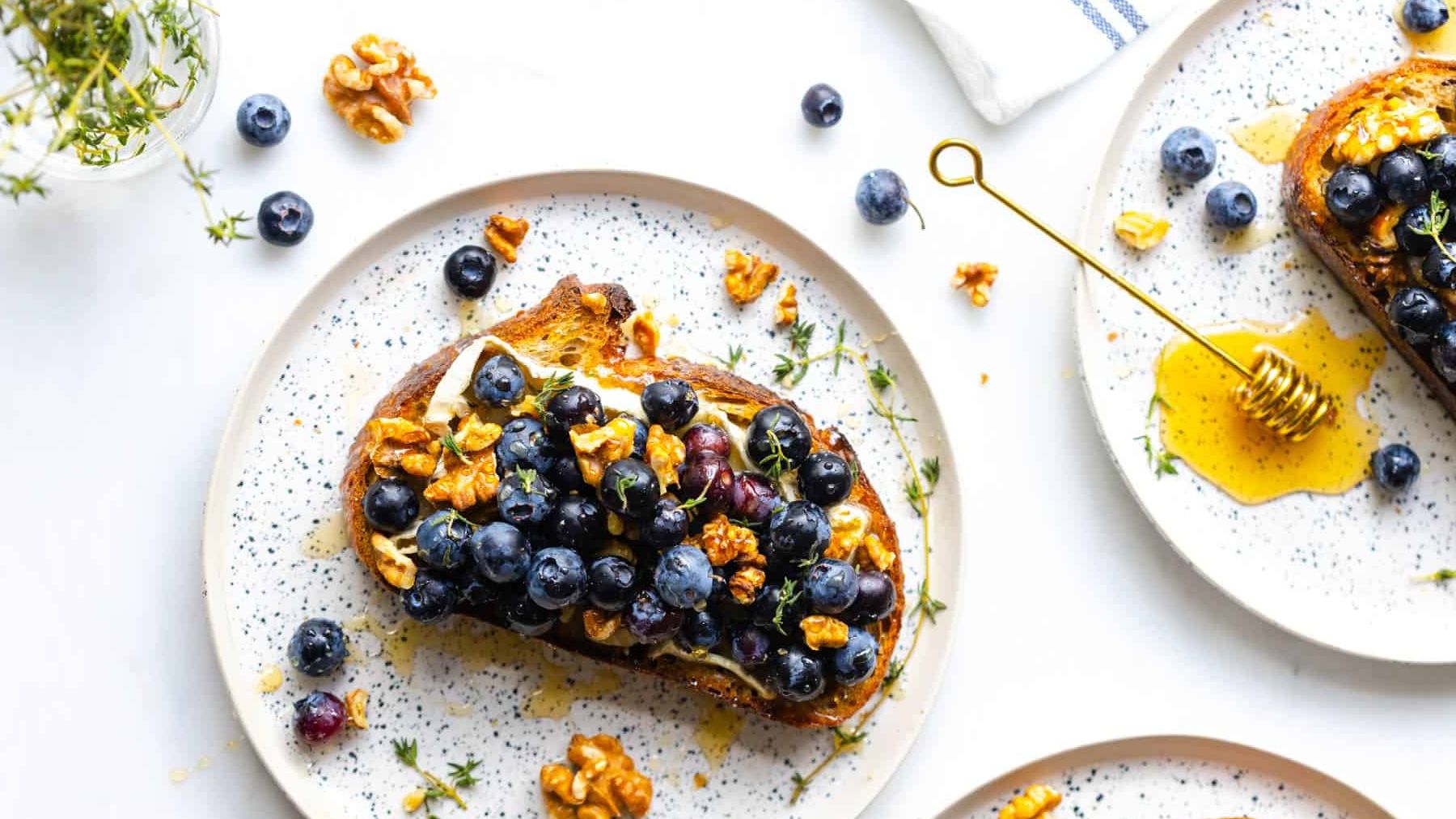 Wheat bread topped with fresh blueberries, representing a balanced, whole-food ingredient choice often used when tracking macros for women’s nutrition and healthy eating.