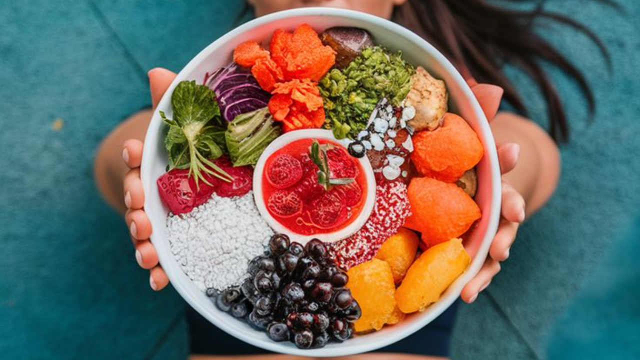 Bowl filled with a variety of whole foods like lean protein, grains, and vegetables, representing balanced calorie intake for women aiming to build muscle and stay lean.