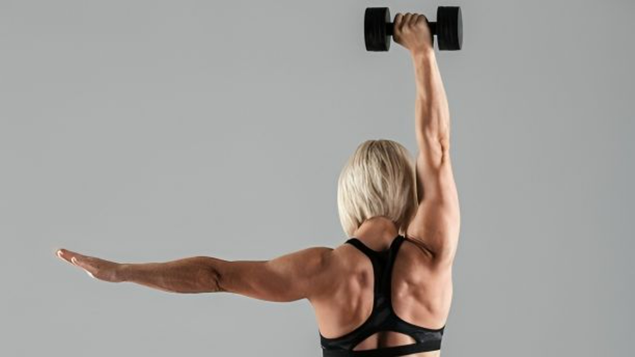 Woman lifting a dumbbell during strength training to improve body composition and build lean muscle.