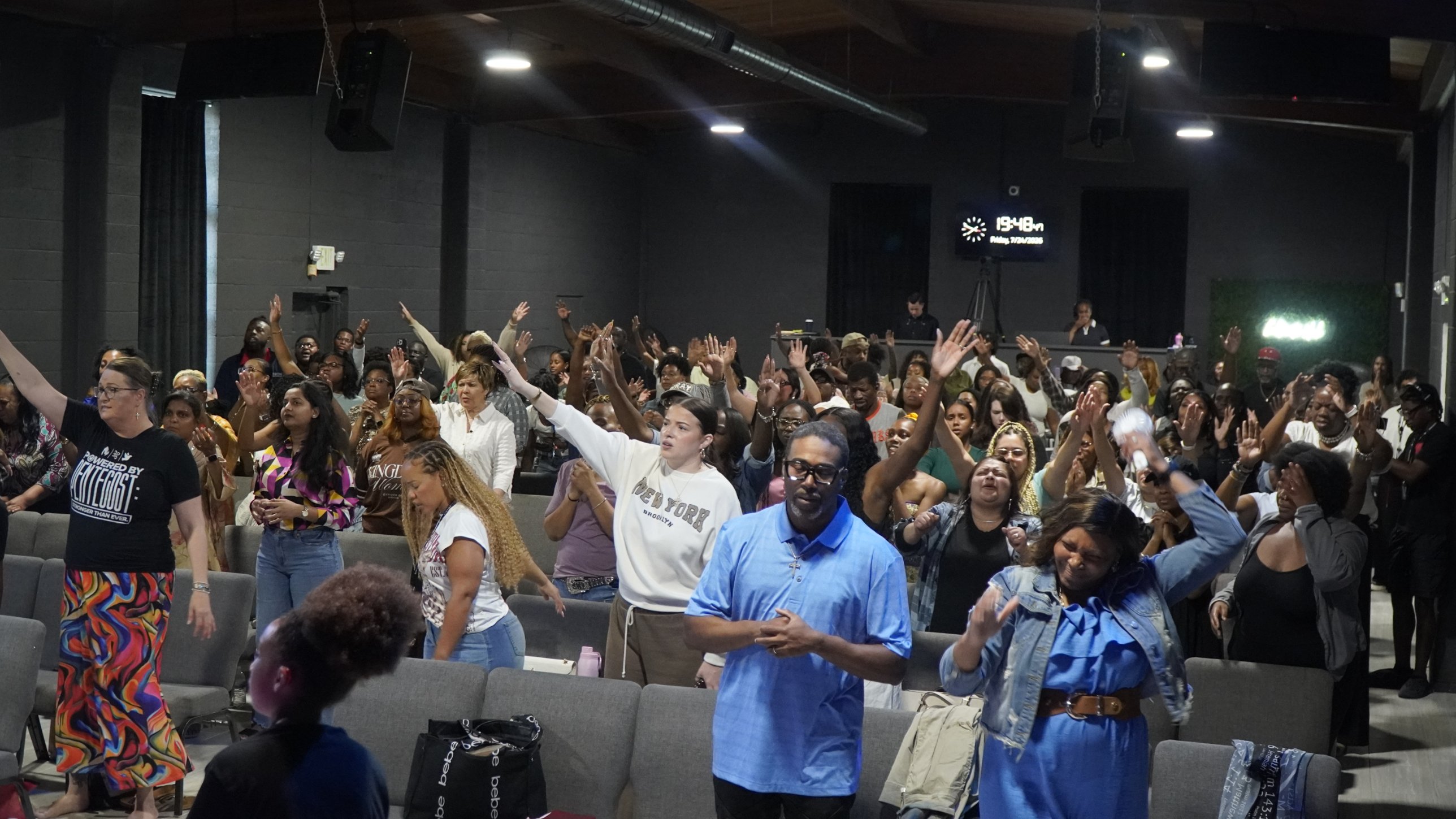 The Cultivate DFW congregation worshiping with hands raised