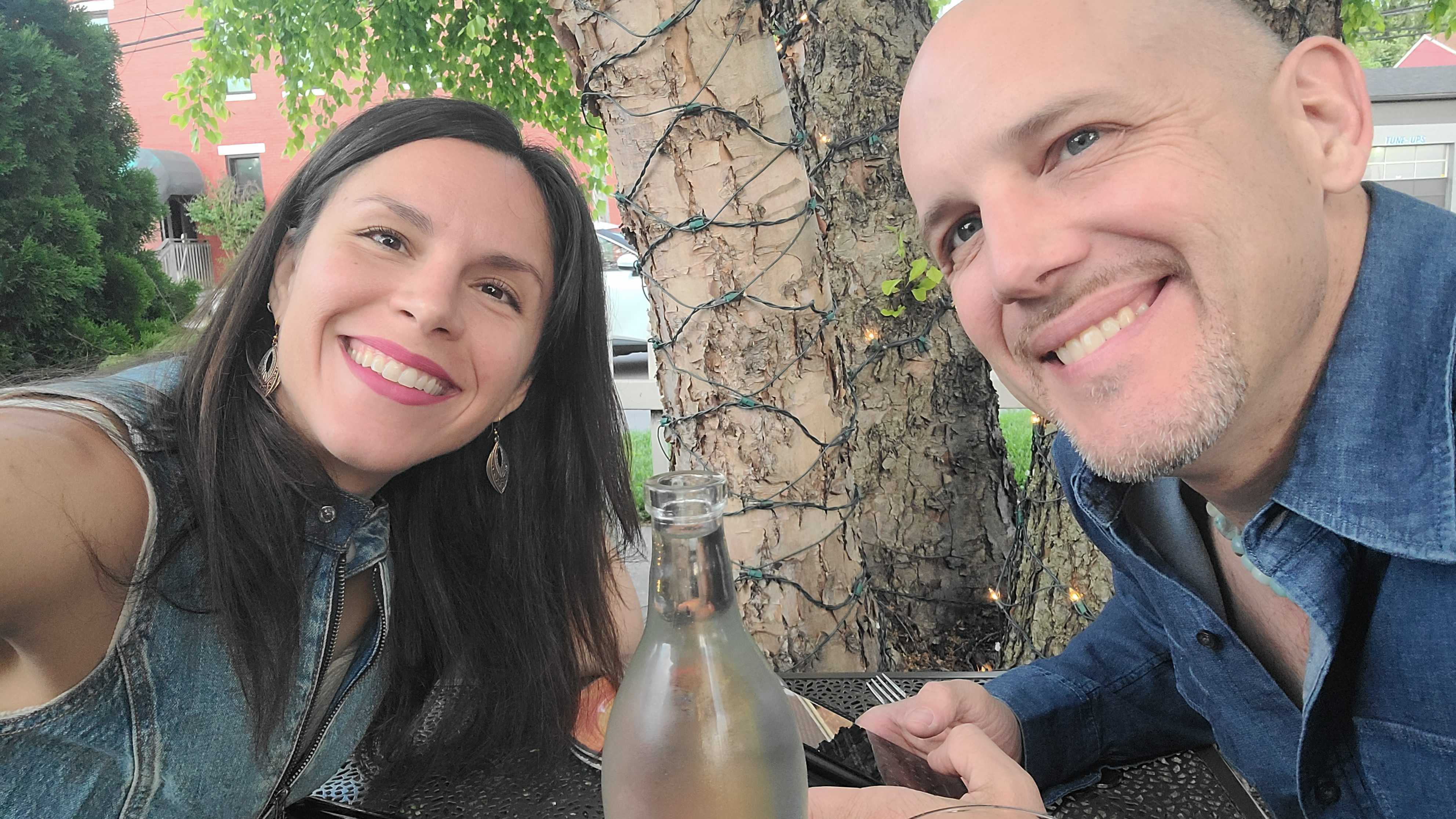 Courtney and Eric smiling on a dinner date outdoors