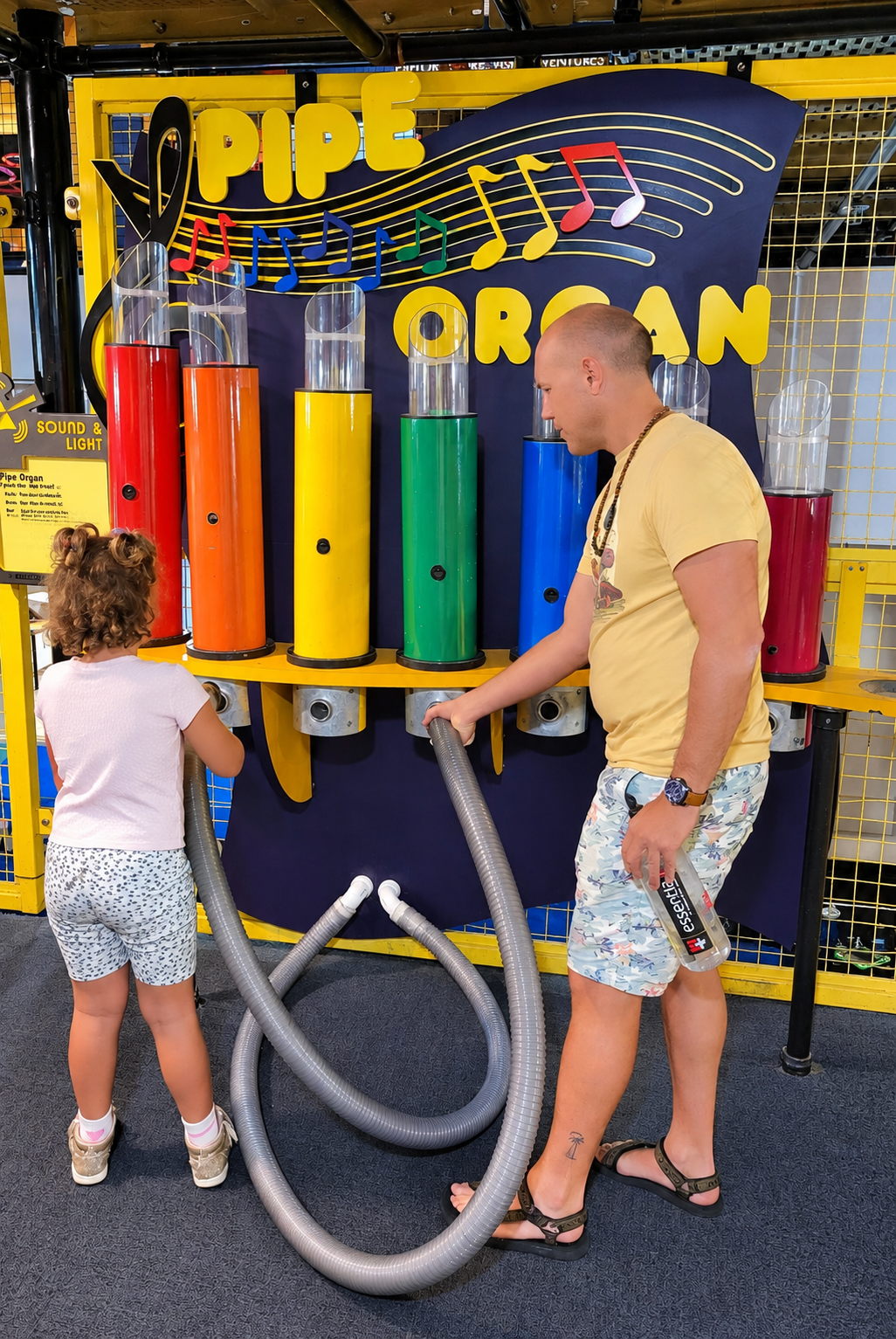Eric and their daughter playing a giant pipe organ at a science museum