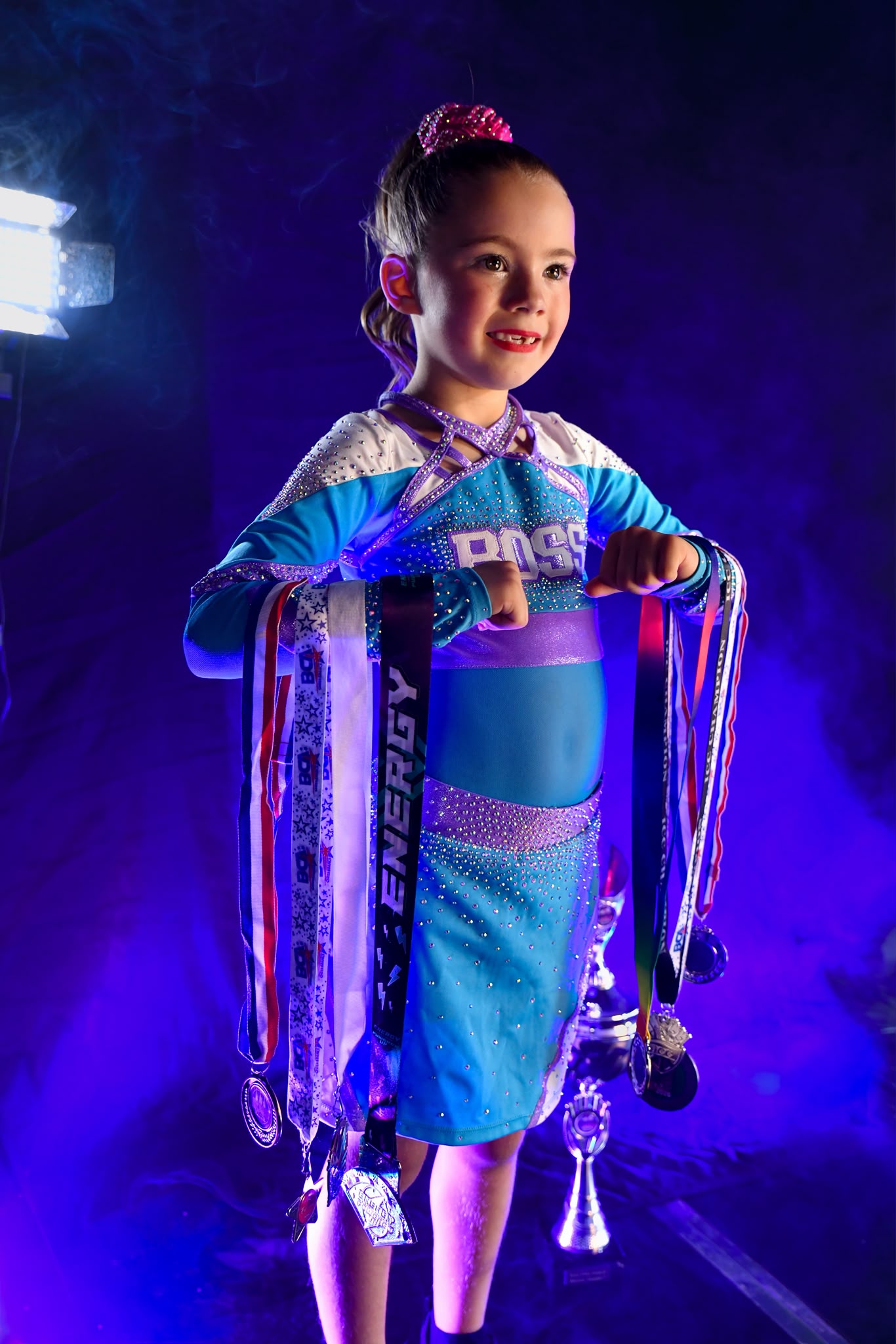 Dynamic Athlete Portrait: athlete with medals and trophy under stage lighting