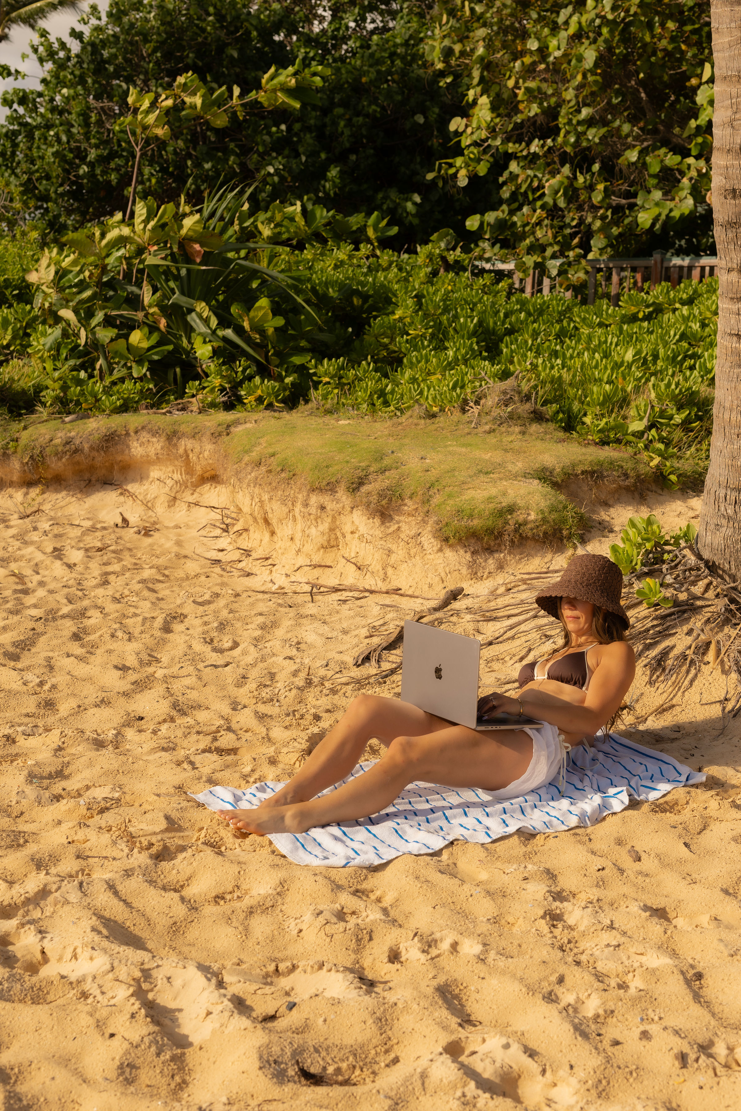 Lindsey writing on her laptop on the beach