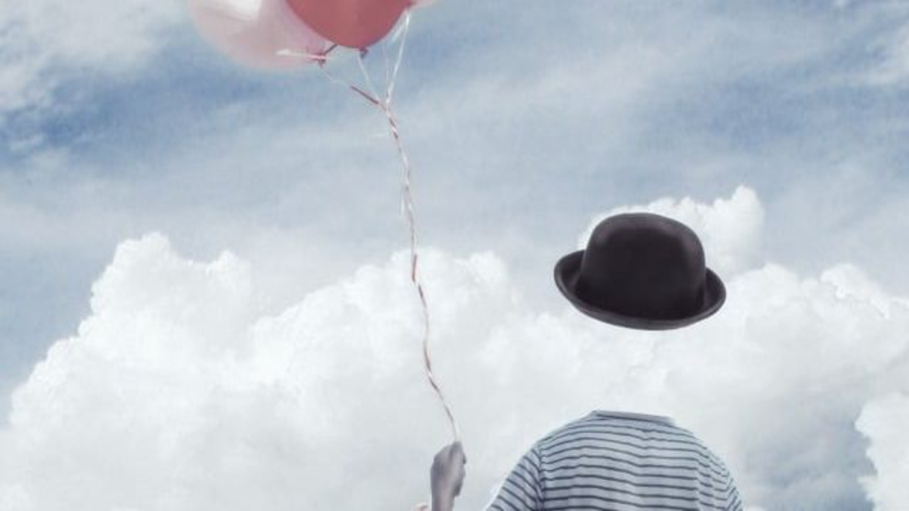 Are we living in a mind-constructed illusion? An human figure without a head holding a bundle of balloons