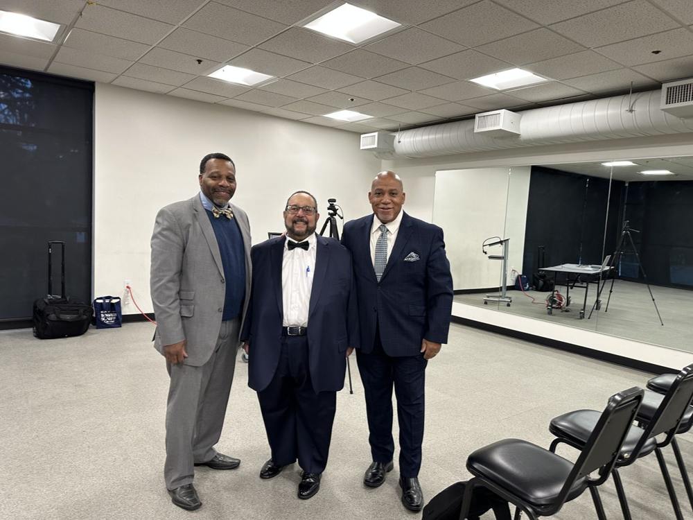 Three men standing together at a church gathering.