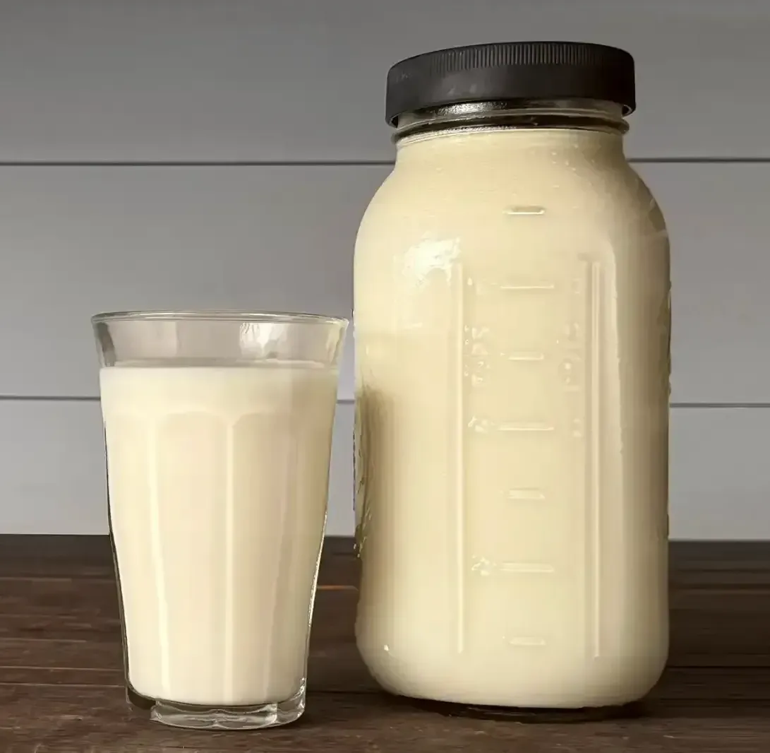 Glass and jar of fresh raw milk from Dexter cows at Mountain Heritage Farm — some produce A2/A2 milk, often considered easier to digest.