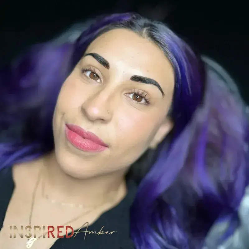 A Hispanic woman with vibrant purple hair showcasing her freshly done bold powder brow permanent makeup.