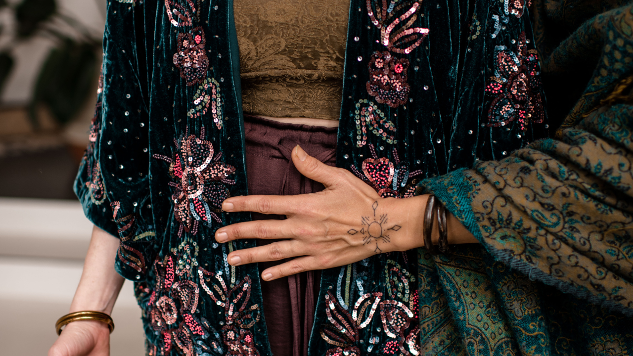 A woman resting her hand on her chest in soft light, sensing the guilt that can follow saying no  A woman sitting quietly by a window in autumn light, reflecting on the guilt that can follow saying no  Hands holding a warm cup of tea, a gentle reminder of learning to receive without repaying  A woman walking alone through an autumn forest, returning to herself after saying no