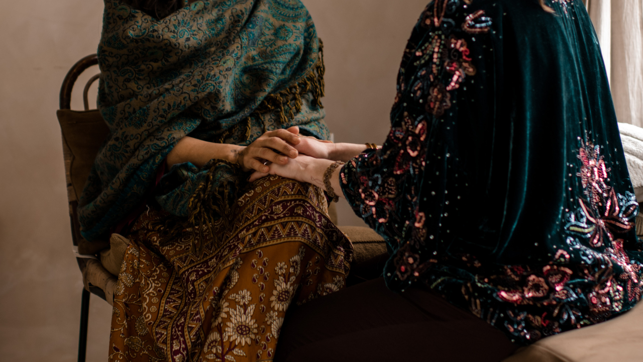 A woman sitting quietly with one hand on her heart, turning her attention inward